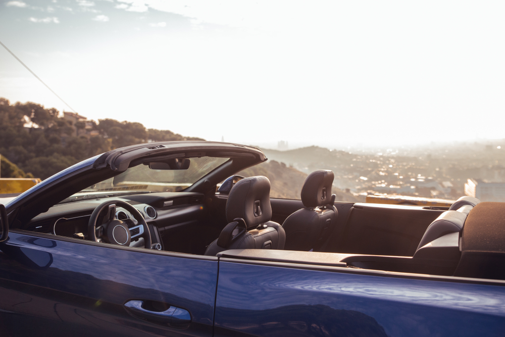 Blue luxury car in gazebo overlooking the city of Barcelona at sunrise