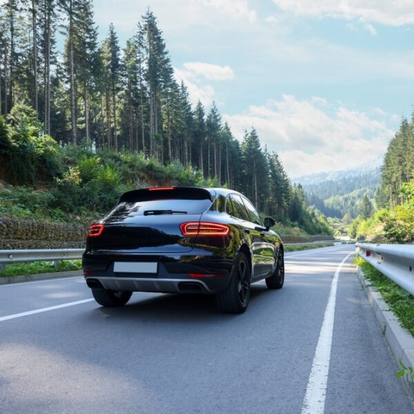 Picturesque view of asphalt road with modern black car